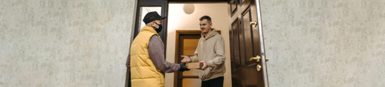 Professional courier handing over a package to a customer, illustrating a reliable weed delivery service at a residential doorstep.